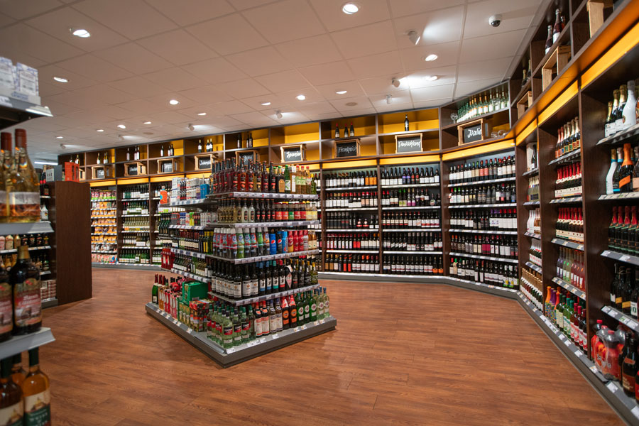 Große Wein- und Spirituosenabteilung mit Mittelgondel und Wandregalen.